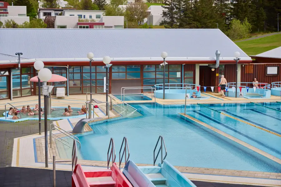 Las piscinas al aire libre de Suðurbæjarlaug, con los jacuzzis y el edificio de vestuarios